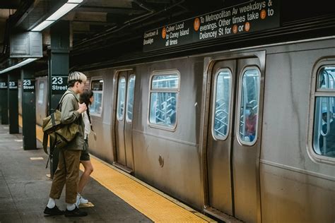 Jeune Couple Debout Devant Le Train Sur La Plate Forme De La Station De