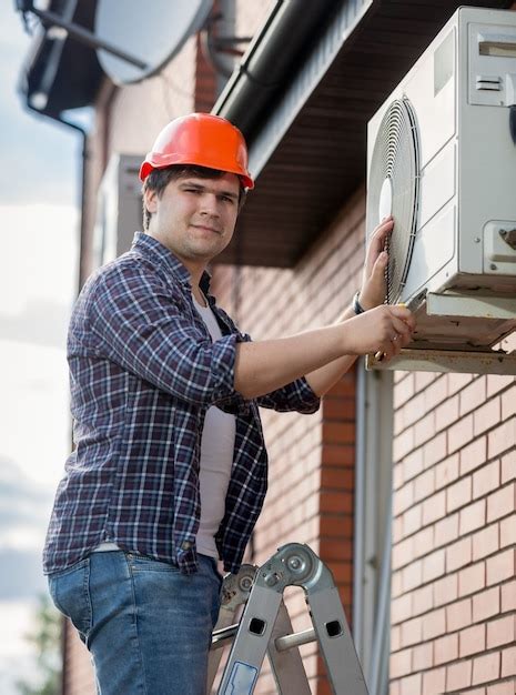 Premium Photo | Portrait of young engineer installing air conditioner