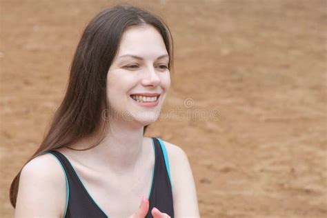 Assento De Sorriso Da Mulher Moreno Bonita Nova Na Areia Na Praia