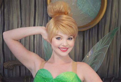 A Woman Dressed As Tinkerbell Posing For The Camera With Her Hands