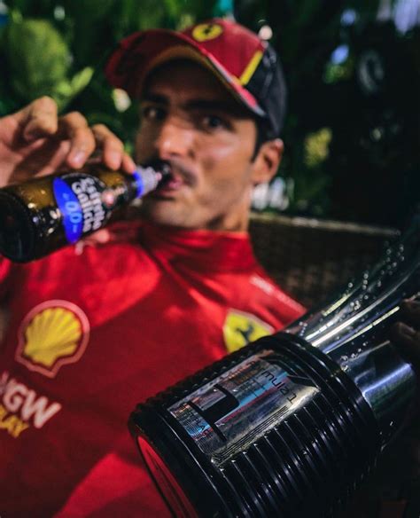 A Man In Red Shirt Drinking From A Bottle