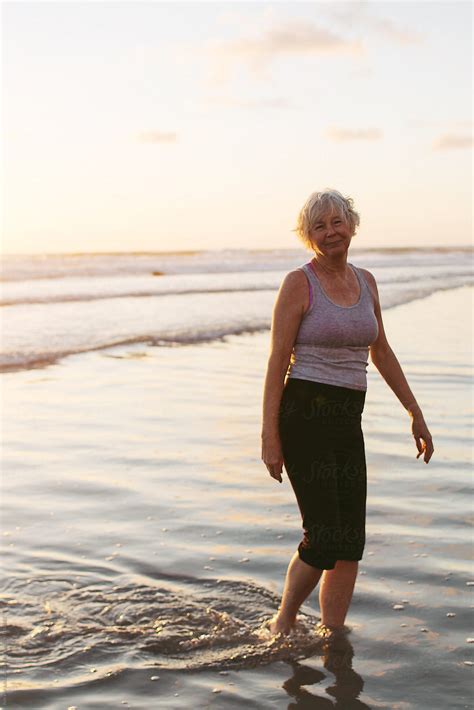 Vibrant Mature Woman Enjoying Herself On The Beach At Sunset By