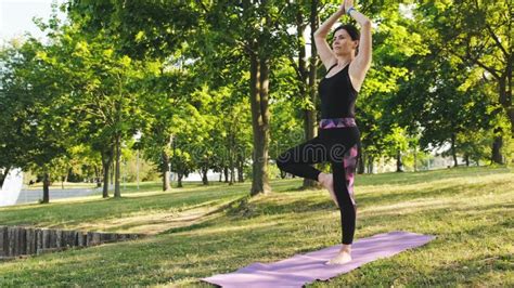 Girl Practicing Yoga In Tree Pose Standing On The Pier At Sunset Back