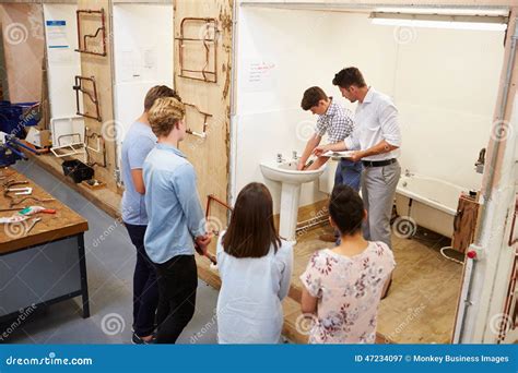 College Students Studying Plumbing Working On Washbasin Stock Image