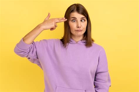 Premium Photo Woman Pointing Finger Gun To Head Shooting Herself