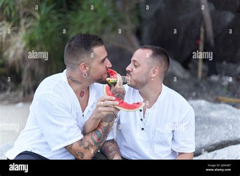 Gay Couple Joking While Feeding Each Other With Watermelon Outdoors Stock Photo Alamy