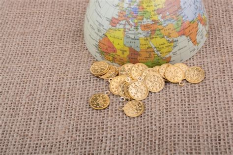 Premium Photo | Fake gold coins beside the globe