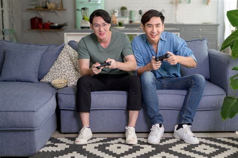 Jovem Casal Gay Sorridente Jogando Videogame Na Sala De Estar Em Casa Lgbtq E Diversidade Foto