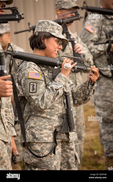 A Woman Drill Sergeant Candidate Prepares Her Weapon For Inspection At