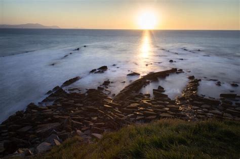 Premium Photo Sea With Rocks And Grass At Dusk