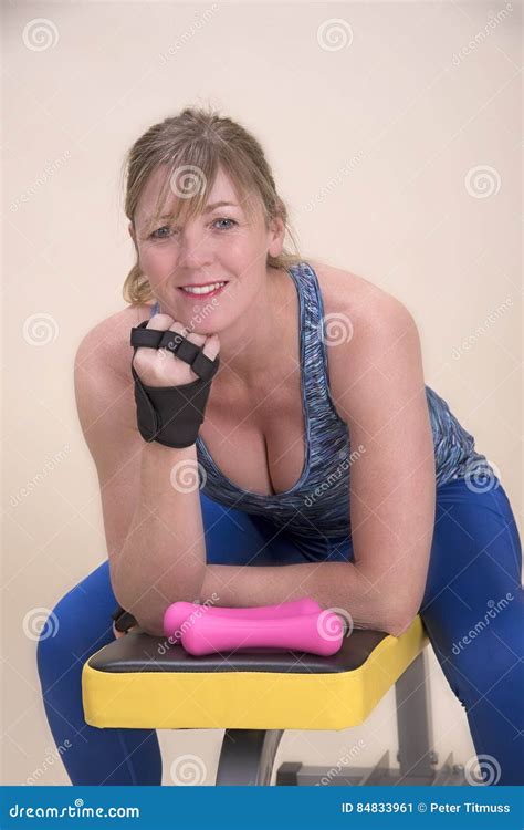 Femme S Asseyant Sur Un Banc De Formation De Gymnase Image Stock