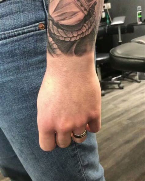 A Man S Arm With A Tattoo On It And A Ring In The Middle