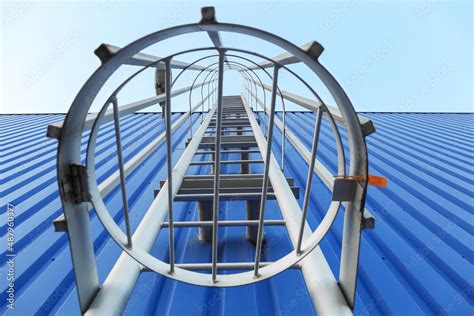 fire escape metal ladder  blue building outdoors closeup stock photo