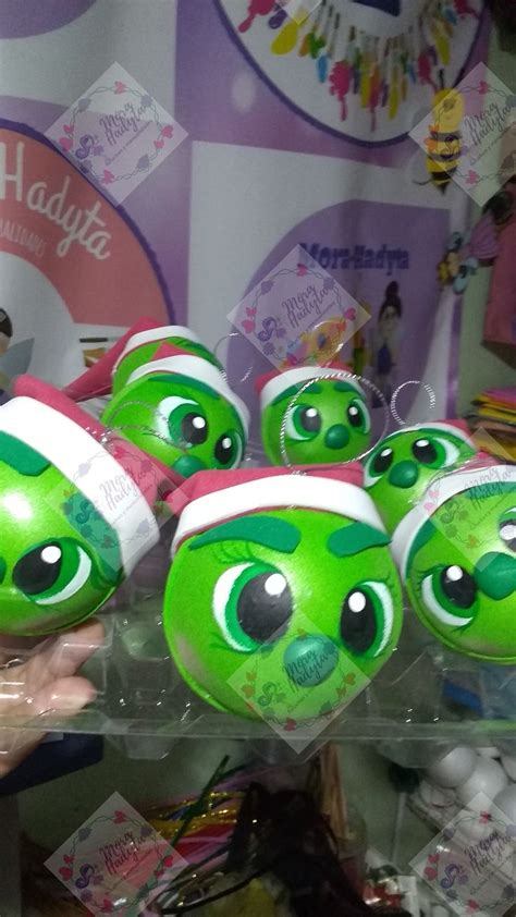 There Are Many Green Balls With Eyes And Hats On Them In The Store