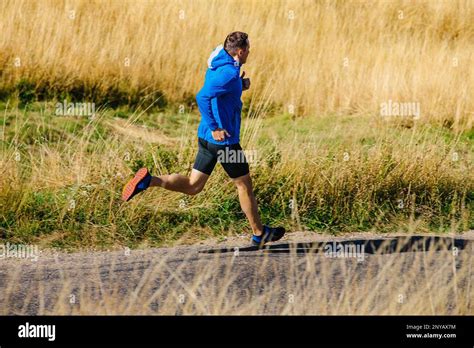 Male Runner Running On Road Among Dry Grass Stock Photo Alamy