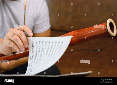 Closeup Of Bassoonist Male Hand Turning Sheet Music Page On Music Stand