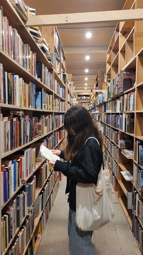 A Woman Is Looking At Books In A Library