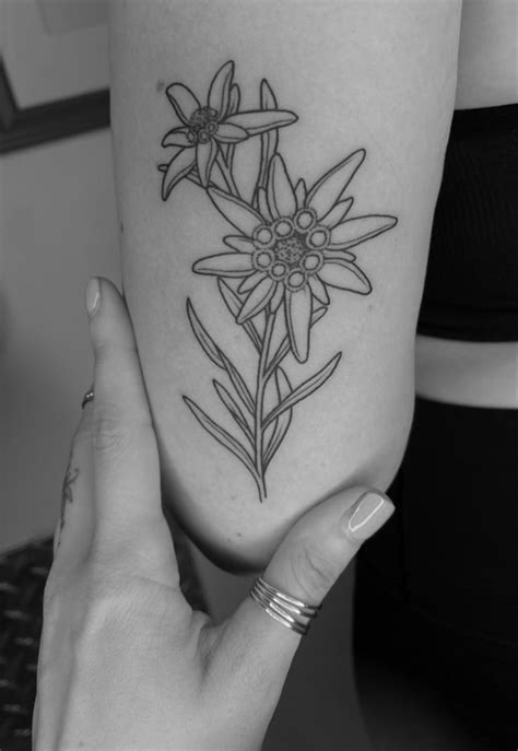 a woman's arm with a flower tattoo on the left side of her leg