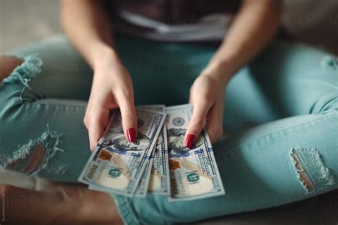 "Woman Holding Money Dollar Bills" by Stocksy Contributor "Ilya" - Stocksy