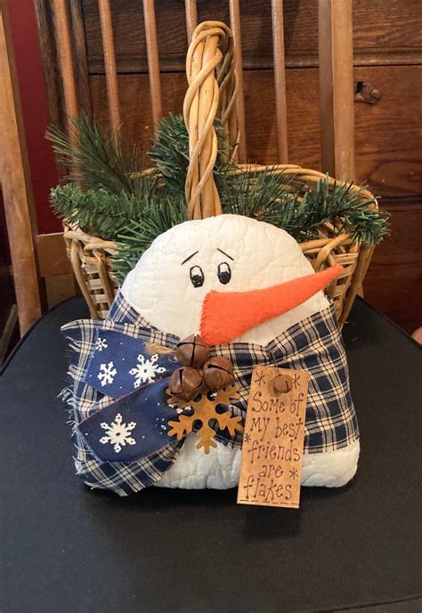 A Snowman Sitting On Top Of A Table Next To A Basket