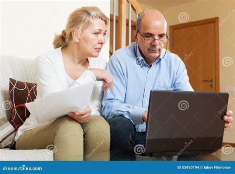 Senior Man With Mature Wife Reading Business Documents Stock Photo