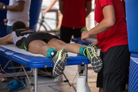 Atleta Que Miente En Una Cama Mientras Que Teniendo Piernas Dadas