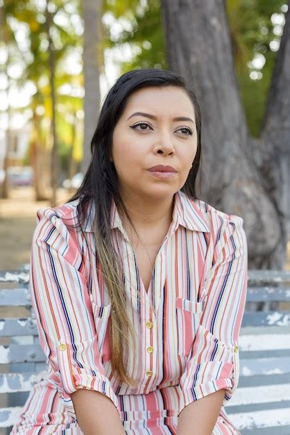 Retrato al aire libre de una mujer con expresión triste sentada en un