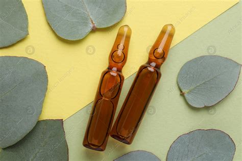 Pharmaceutical Ampoules With Medication And Eucalyptus Leaves On Color Background Flat Lay