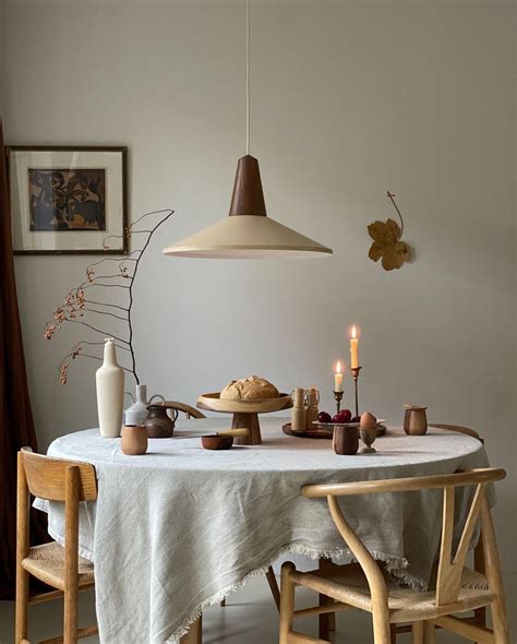 A White Table With Two Chairs And A Light Hanging Over It