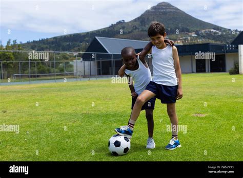 biracial boy  african american boy play soccer outdoors  school