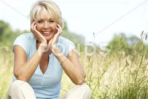 Portrait Of Mature Woman Sitting In Countryside Premium Photo