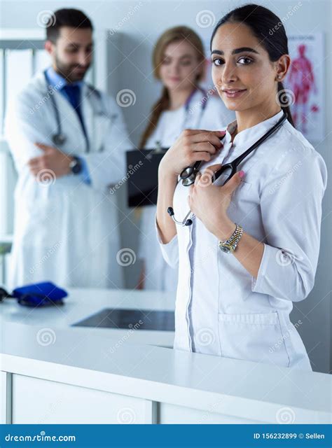 Portrait Of Young Woman Doctor With White Coat Standing In Hospital