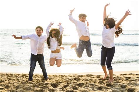 Enfants Heureux Sautant Ensemble Sur La Plage Image Stock Image Du