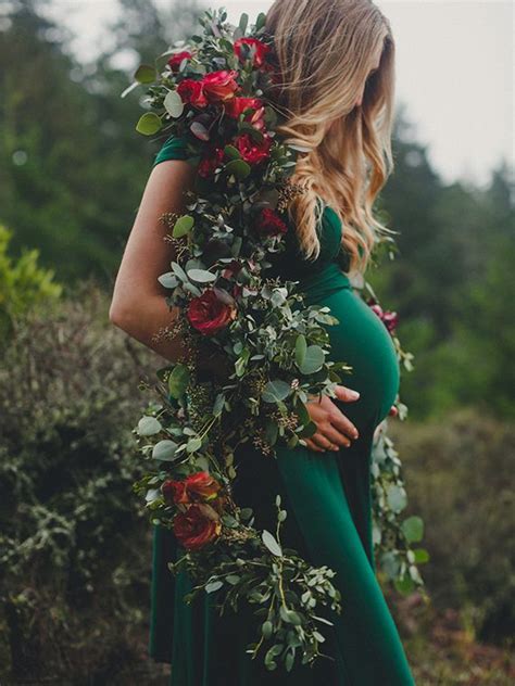 A Pregnant Woman In A Green Dress With Flowers Around Her Neck And