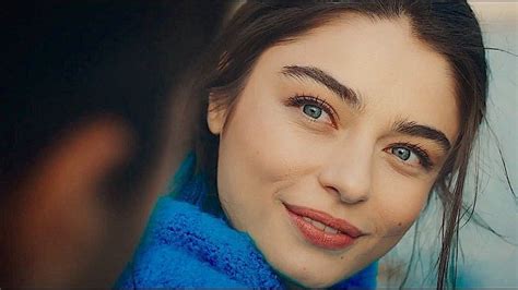 A Close Up Of A Person Wearing A Blue Coat And Smiling At The Camera