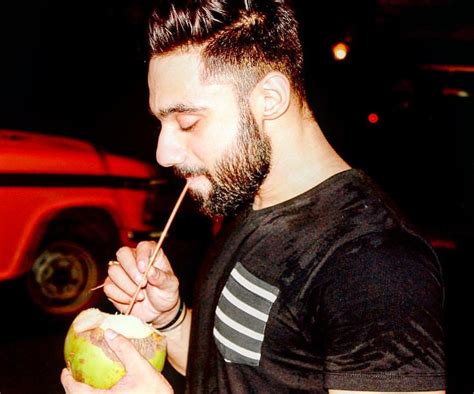 A Man With A Straw In His Mouth Eating An Apple