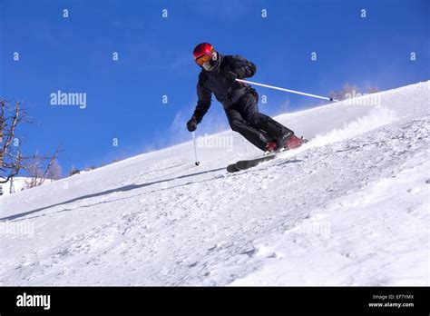 Skier With A Mask On Face Skiing Downhill In High Mountains And Sunny