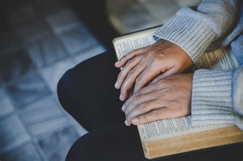 Premium Photo Hands Folded In Prayer On A Holy Bible In Church