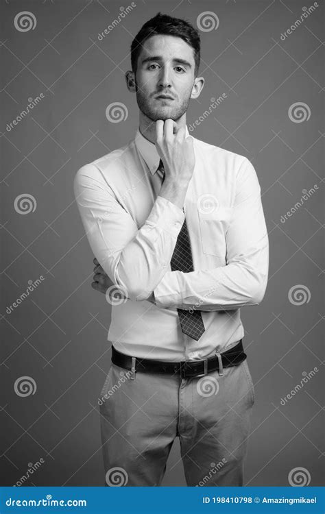 Retrato De Joven Y Apuesto Hombre De Negocios Sobre Fondo Gris Foto De