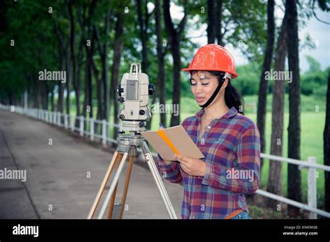 Hembra ingeniero topógrafo o hacer medir por el teodolito en la calle