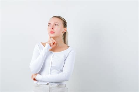 La fille blonde pense à n importe quoi sur le fond blanc Photo Gratuite
