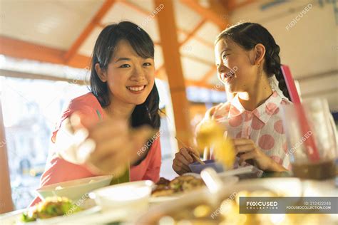 Happy Asian Mother And Daughter Eating Food Together — Happiness Light