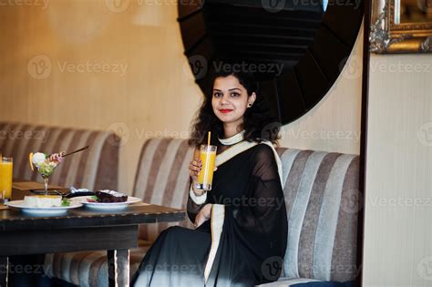 Young Indian Woman Wear At Elegant Black Saree Sitting On Restaurant