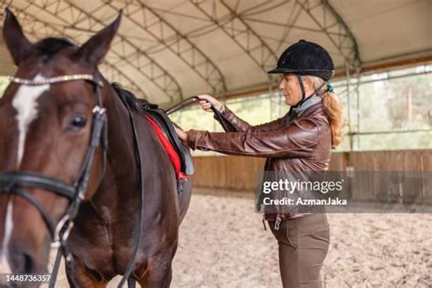 13 Woman Saddling Up Horse In Field Stock Photos, High-Res Pictures ...