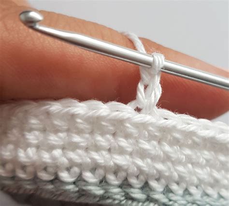 Someone Is Crocheting The End Of A Piece Of White Yarn