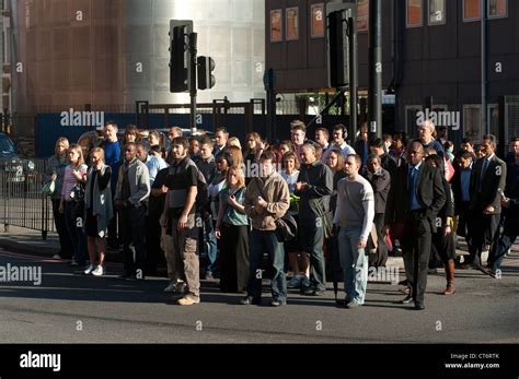 Pedestrians Waiting To Cross A Busy Road In The Centre Of The City Of