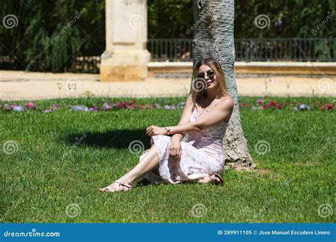 Joven Y Hermosa Mujer Rubia Y Latina Sentada A La Sombra Al Lado Del Tronco De Una Palmera En El