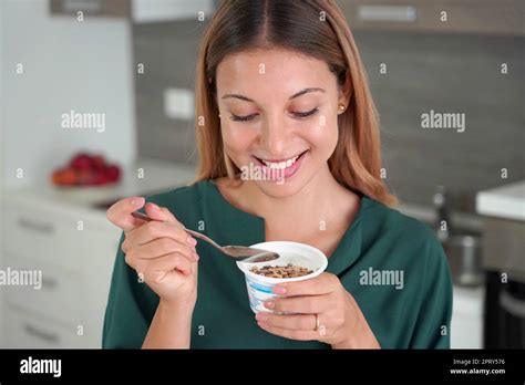 Sweet Woman Holds Bowl Of Greek Yogurt With Muesli In The Kitchen Stock