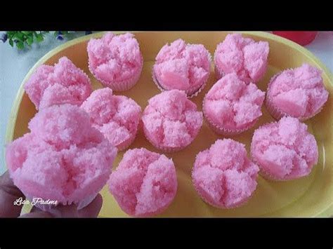 Pink Cupcakes Are On A Yellow Plate And Someone Is Holding Them In