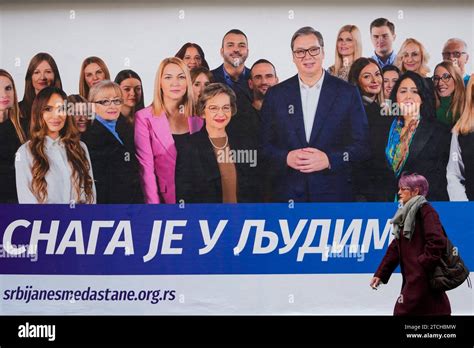 A Woman Walks Past A Pre Election Billboard Showing Serbian President